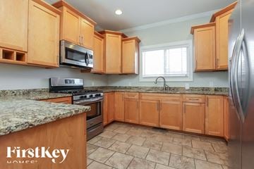 Clarksville house for rent - A kitchen with wooden cabinets and granite countertops.