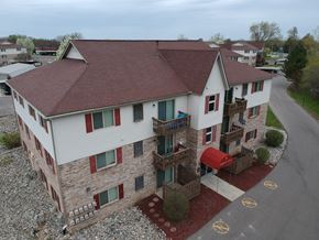 Durand apartment for rent - a aerial view of a white house with balconies and a red mailbox