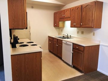 Durand apartment for rent - a kitchen with wooden cabinets and a stove and a sink