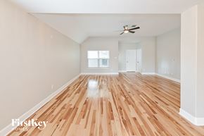 Conroe house for rent - a renovated living room with hardwood floors and a ceiling fan