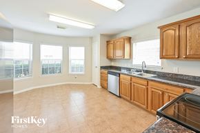 Conroe house for rent - a kitchen with wooden cabinets and granite counter tops and a sink