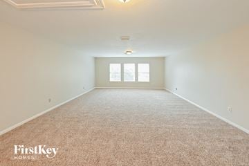 Conroe house for rent - a spacious living room with carpet and a window