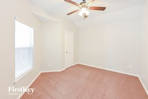 Conroe house for rent - a bedroom with a ceiling fan and a window