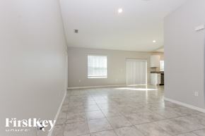Port St. Lucie house for rent - A spacious empty room with a large window and tiled floor.
