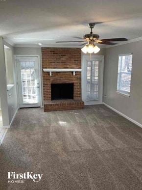 Charlotte house for rent - an empty living room with a fireplace and a ceiling fan