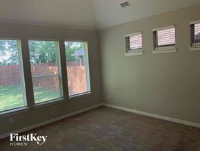 Melissa house for rent - a bedroom with three windows and a carpeted floor