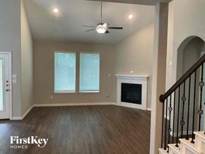 Melissa house for rent - an empty living room with a ceiling fan and a fireplace