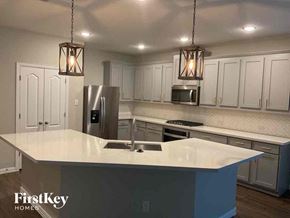 Melissa house for rent - a kitchen with white cabinets and a counter top