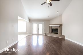 Plainfield house for rent - an empty living room with a fireplace and a ceiling fan