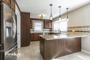 Plainfield house for rent - a kitchen with stainless steel appliances and a marble counter top