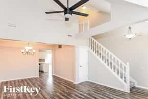 Avon house for rent - A spacious room with a staircase and a ceiling fan.