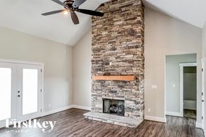 Bessemer house for rent - A stone fireplace with a fan above it in a room.