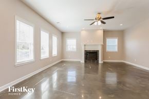 Madison house for rent - an empty living room with a fireplace and a ceiling fan