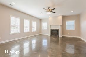 Madison house for rent - an empty living room with a fireplace and a ceiling fan