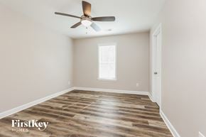 Madison house for rent - the spacious living room with wood floors and a ceiling fan