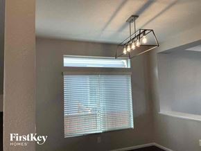 Commerce City house for rent - a dining room with a window and a chandelier