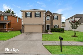 Jacksonville house for rent - a beige and brick house with a driveway and lawn