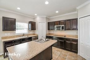 Jacksonville house for rent - a kitchen with granite counter tops and black cabinets