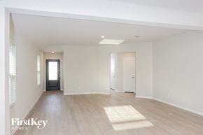 San Antonio house for rent - A spacious empty room with wooden floors and white walls.