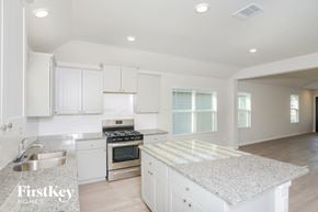 San Antonio house for rent - A kitchen with white cabinets and a granite countertop.