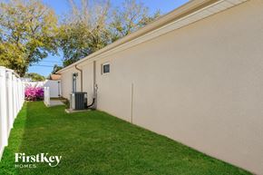 Venice house for rent - a side view of a house with a grass lawn and a backdoor
