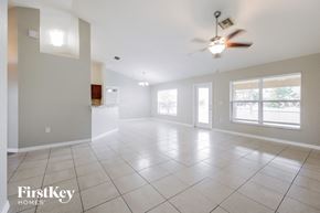 Lehigh Acres house for rent - A spacious room with a fan and large windows.