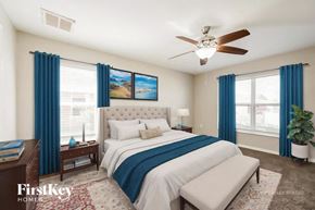 Lehigh Acres house for rent - A bedroom with a large bed and a ceiling fan.