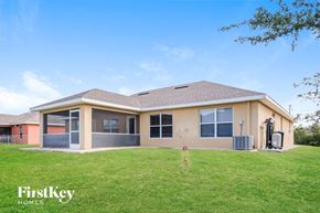 Lehigh Acres house for rent - A house with a brown roof and a beige exterior is shown with the words "FirstKey Homes" on the bottom left.
