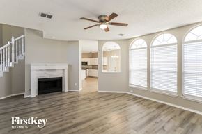 Rowlett house for rent - a living room with a fireplace and a ceiling fan