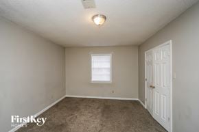 Memphis house for rent - a bedroom with a carpeted floor and a white door