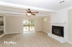 Bartlett house for rent - A spacious living room with a fireplace and sliding glass doors.