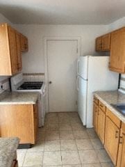 Trinidad house for rent - a kitchen with wooden cabinets and a white refrigerator