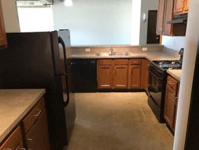 Cleveland apartment for rent - a kitchen with wooden cabinets and a black refrigerator