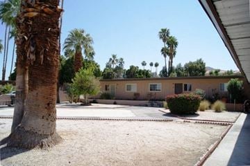Cathedral City apartment for rent - a courtyard with palm trees and a building in the background