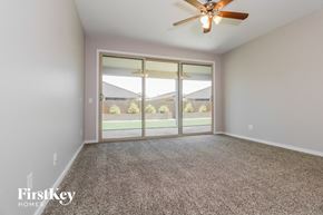 Surprise house for rent - A room with a carpet floor and a ceiling fan.