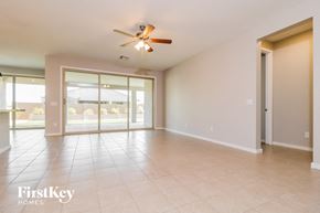 Surprise house for rent - A spacious room with a ceiling fan and sliding glass doors.