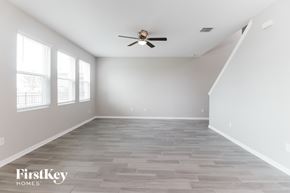 Wesley Chapel house for rent - A spacious room with a fan and wooden flooring.