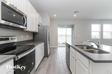 Wesley Chapel house for rent - A modern kitchen with white cabinets and stainless steel appliances.