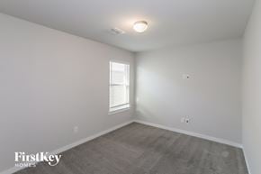 Fort Worth house for rent - a bedroom with white walls and gray carpet and a window