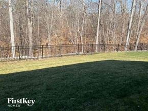 Mooresville house for rent - A grassy field with trees in the background and a fence running along the edge of the field.