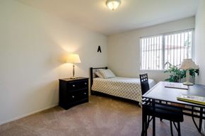Pontiac apartment for rent - a bedroom with a bed and a dining room table and a window