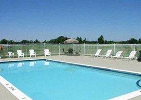 Davison apartment for rent - a large swimming pool with white chairs