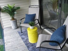 Saginaw apartment for rent - a porch with two chairs and a yellow vase with plants