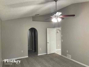 Jacksonville house for rent - a living room with a ceiling fan and a white door