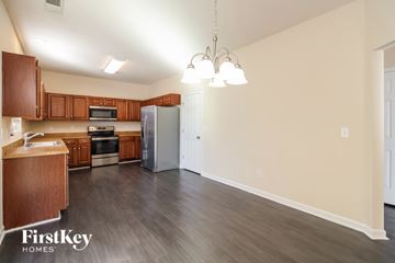 Greensboro house for rent - A kitchen with wooden cabinets and a grey refrigerator.
