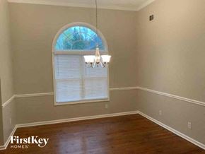 Monroe house for rent - an empty dining room with a window and a chandelier