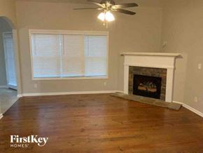 Monroe house for rent - a living room with a fireplace and a ceiling fan