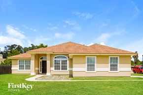 Middleburg house for rent - A house with a red roof and a sign that says "FirstKey Homes" in front of it.