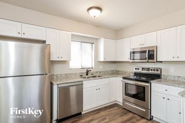Glendale house for rent - a kitchen with white cabinets and stainless steel appliances