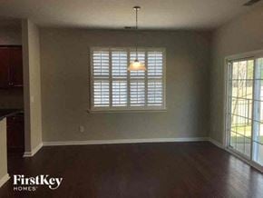 Belmont house for rent - an empty living room with a large window and wood floors